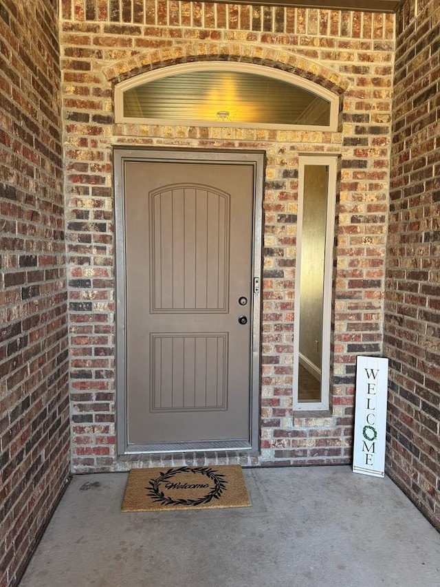 doorway to property featuring brick siding