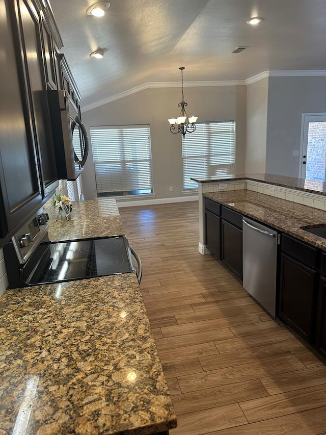 kitchen with crown molding, stainless steel appliances, an inviting chandelier, vaulted ceiling, and wood finished floors