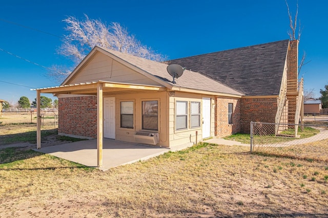 back of property with a yard and a patio