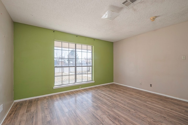 spare room with wood-type flooring and a textured ceiling