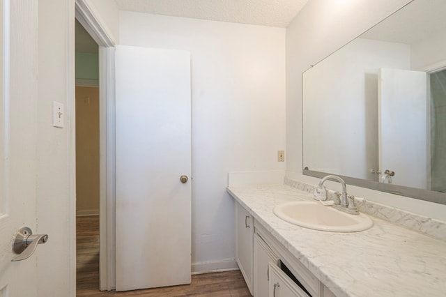 bathroom with vanity, hardwood / wood-style floors, and a textured ceiling