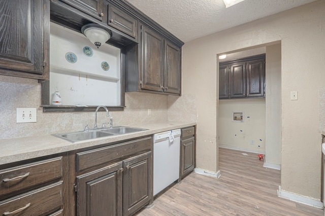 kitchen featuring dishwasher, sink, backsplash, a textured ceiling, and light hardwood / wood-style flooring