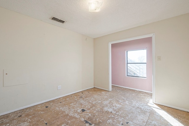 spare room with a textured ceiling