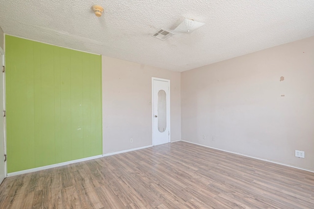 empty room featuring light hardwood / wood-style flooring and a textured ceiling