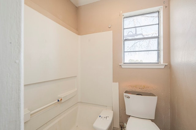 bathroom with a tub and toilet