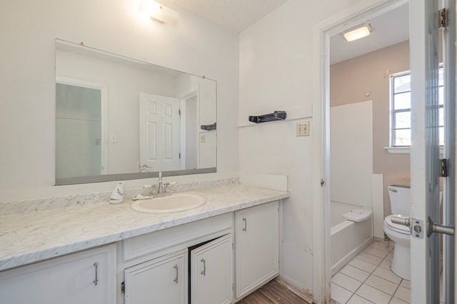 bathroom featuring tile patterned floors, vanity, toilet, and a bathtub