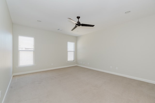 unfurnished room with light colored carpet, baseboards, and ceiling fan