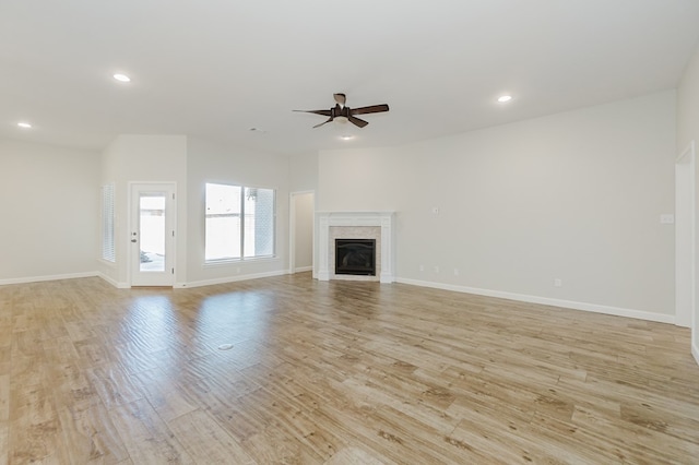 unfurnished living room with a ceiling fan, baseboards, light wood-style flooring, recessed lighting, and a fireplace