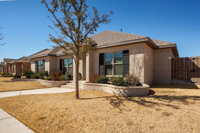 single story home with fence and brick siding