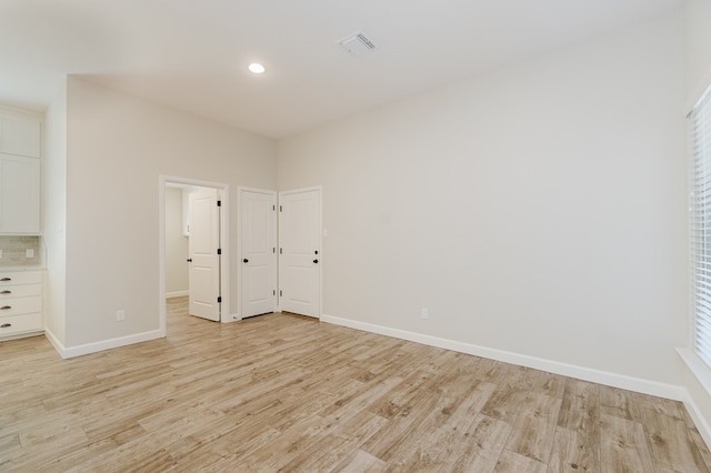 unfurnished bedroom featuring light wood finished floors, visible vents, recessed lighting, and baseboards