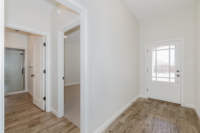 doorway to outside with light wood-style flooring, baseboards, and visible vents