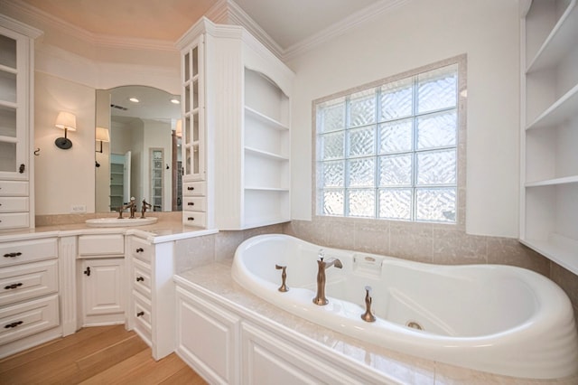 bathroom featuring a bathing tub, built in shelves, hardwood / wood-style flooring, vanity, and ornamental molding