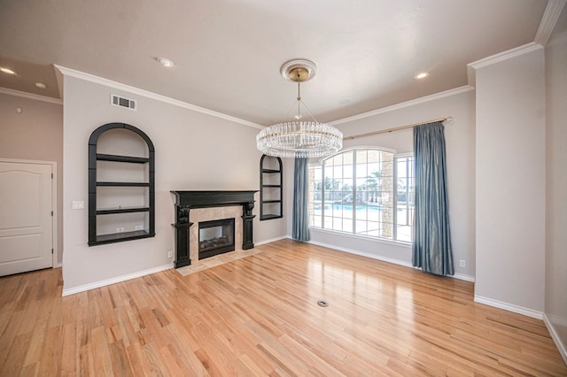 unfurnished living room with ornamental molding, a notable chandelier, and light wood-type flooring