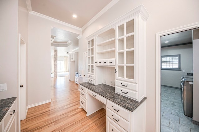 kitchen featuring white cabinets, separate washer and dryer, and light hardwood / wood-style flooring