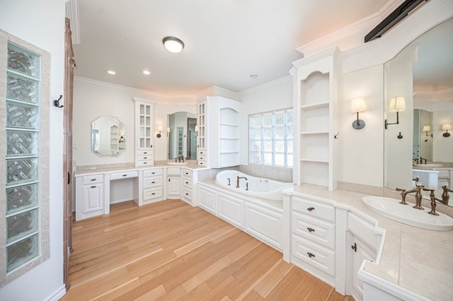 bathroom with a bathing tub, hardwood / wood-style floors, vanity, and ornamental molding