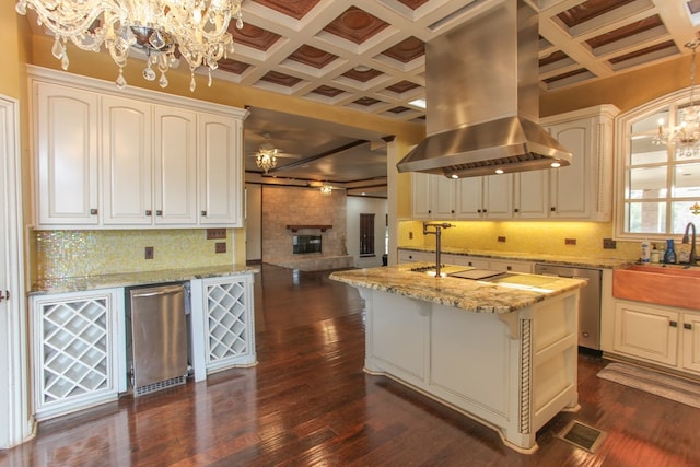 kitchen featuring island range hood, a fireplace, stainless steel dishwasher, and dark hardwood / wood-style floors