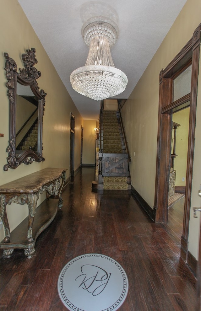 hallway featuring dark hardwood / wood-style floors and a chandelier