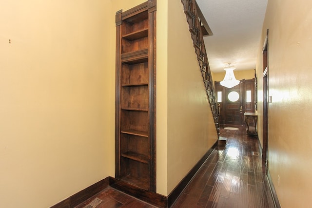 hall with a textured ceiling and dark hardwood / wood-style floors