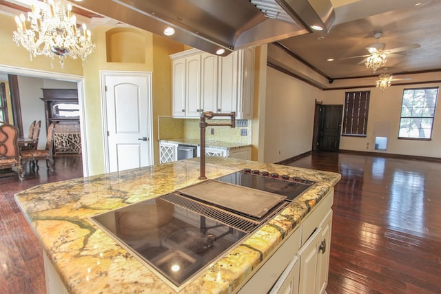 kitchen with black electric stovetop, decorative light fixtures, a kitchen island, and dark wood-type flooring