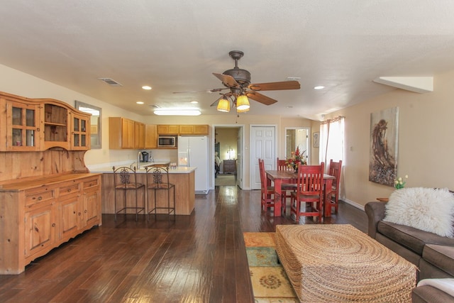 living room featuring ceiling fan, dark wood-type flooring, and a textured ceiling