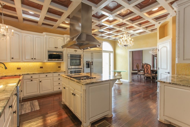 kitchen with island range hood, built in appliances, decorative light fixtures, beamed ceiling, and a kitchen island