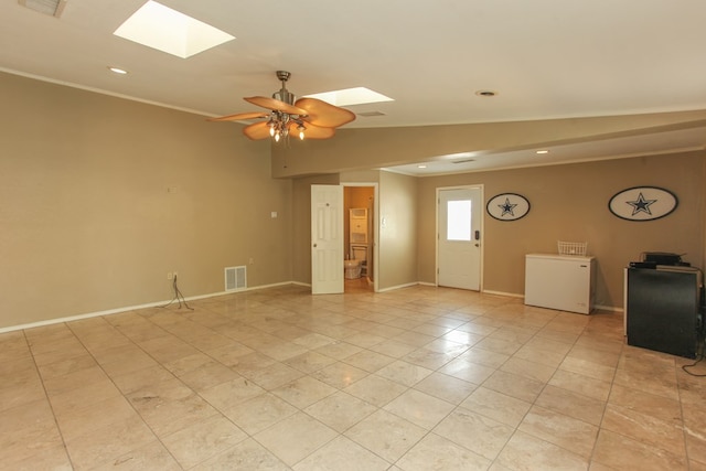 unfurnished living room with ceiling fan, light tile patterned floors, crown molding, and lofted ceiling with skylight