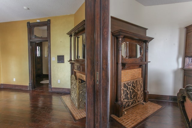 hall featuring a textured ceiling and dark wood-type flooring