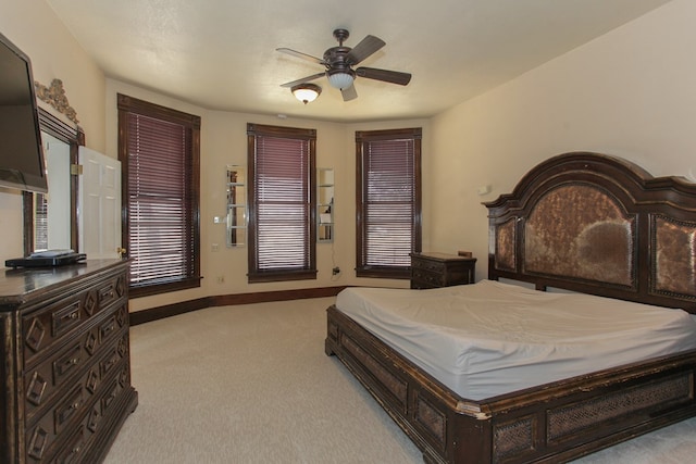 bedroom with ceiling fan, light colored carpet, and a textured ceiling