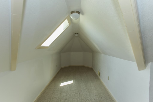 bonus room featuring light colored carpet and lofted ceiling with skylight