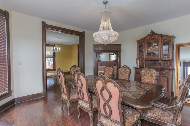 dining space with a textured ceiling, plenty of natural light, dark hardwood / wood-style floors, and a notable chandelier