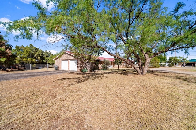 single story home featuring a garage, driveway, a front yard, and fence