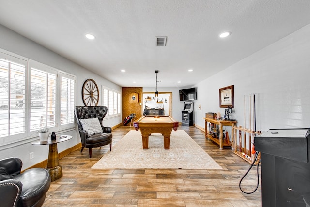 rec room with pool table, wood-type flooring, and a textured ceiling