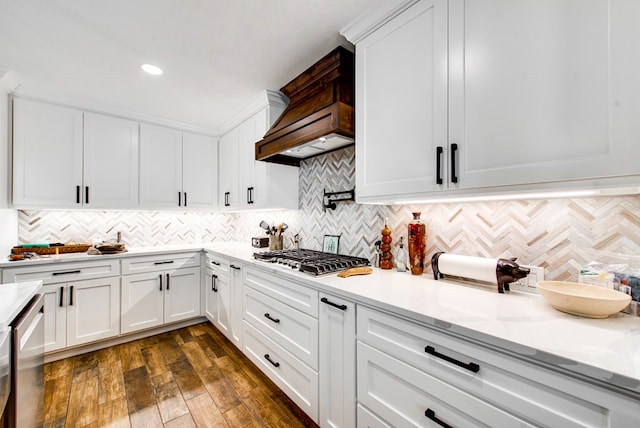 kitchen with tasteful backsplash, white cabinetry, dark hardwood / wood-style flooring, stainless steel appliances, and light stone countertops