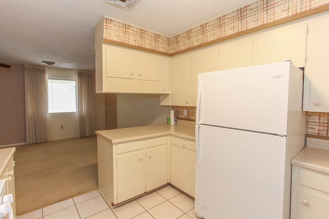 1900 Goliad St, Big Spring, TX 79720 - kitchen with freestanding refrigerator, light countertops, a textured ceiling, light carpet, and light tile patterned flooring