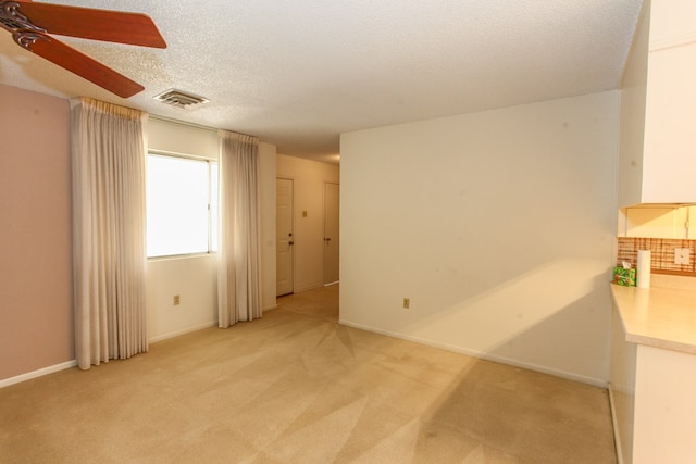 1900 Goliad St, Big Spring, TX 79720 - spare room featuring a ceiling fan, light carpet, a textured ceiling, and baseboards