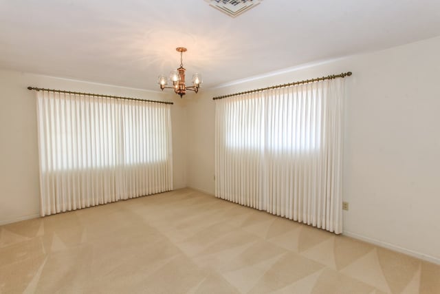 1900 Goliad St, Big Spring, TX 79720 - carpeted spare room with a chandelier