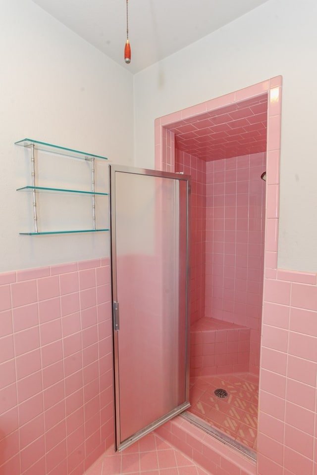 1900 Goliad St, Big Spring, TX 79720 - bathroom featuring a shower stall, tile walls, and wainscoting