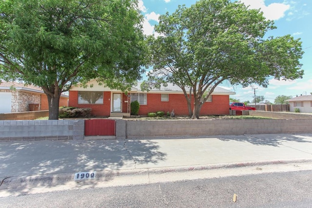 1900 Goliad St, Big Spring, TX 79720 - ranch-style house featuring brick siding, a fenced front yard, and a gate