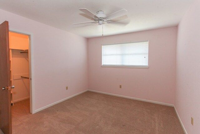 1900 Goliad St, Big Spring, TX 79720 - unfurnished bedroom with a walk in closet, light colored carpet, and baseboards
