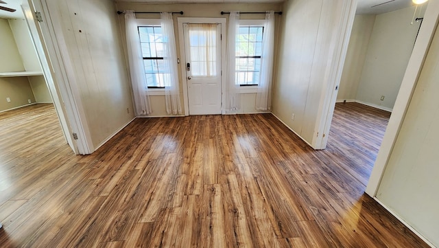 doorway to outside with wood finished floors and a ceiling fan