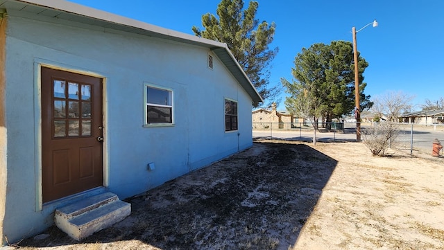 exterior space featuring fence and stucco siding