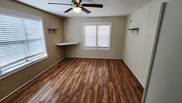 empty room with a healthy amount of sunlight, a ceiling fan, and wood finished floors