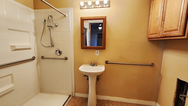 full bath featuring a shower stall and baseboards