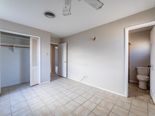 unfurnished bedroom with baseboards, visible vents, a closet, and light tile patterned flooring