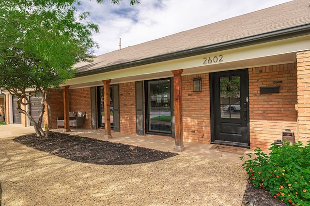 2602 N L St, Midland, TX 79705 - entrance to property featuring brick siding, covered porch, and concrete driveway