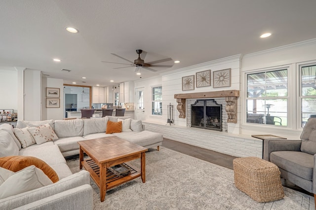 2602 N L St, Midland, TX 79705 - living room with crown molding, a ceiling fan, a fireplace with raised hearth, and recessed lighting