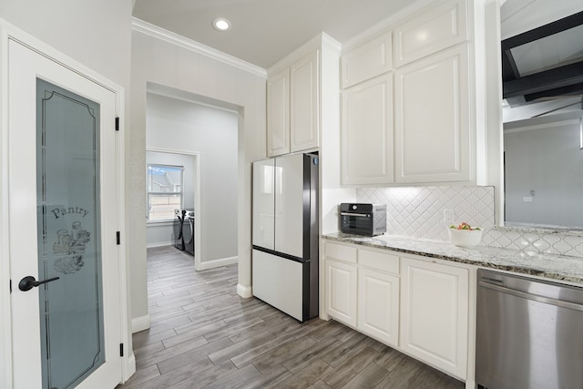 kitchen with tasteful backsplash, dishwasher, white cabinets, white refrigerator, and light stone countertops