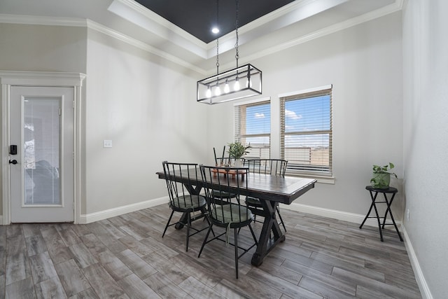 dining room with hardwood / wood-style flooring, ornamental molding, and a tray ceiling