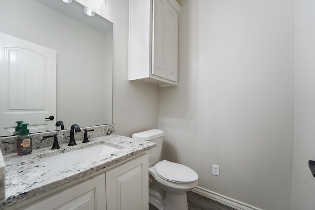 bathroom featuring vanity, wood-type flooring, and toilet