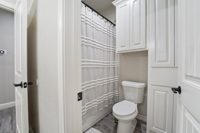 bathroom featuring hardwood / wood-style flooring and toilet